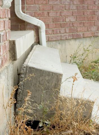 sinking outdoor concrete steps showing cracking and soil washout in Simsbury