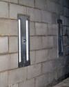 an inside view of foundation wall anchors installed along a basement wall to brace and repair the structure in Torrington