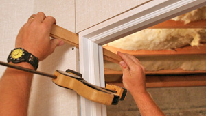 Installing trim and finishing touches to a remodeled basement in Milford, CT