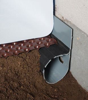 Closeup of a crawl space drainage system installed in Avon