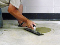 Repairing the cored holes in the concrete slab floor with fresh concrete and cleaning up the Trumbull home.