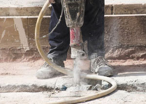 Jackhammering a slab floor in a Milford home.