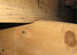 A failing girder showing signs of compression damage in a New Milford home
