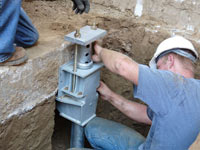 Foundation repair contractors installing the foundation bracket in West Hartford.