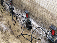Using foundation push piers to lift a foundation during a repair in Darien.