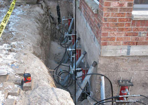 Foundation push piers installed around a house with a foundation settlement issues in Avon