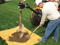 Auguring a hole in the earth for a foundation wall repair system in Trumbull