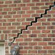 stair step cracking reaching from a window along the foundation wall in West Hartford