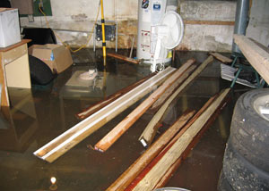 A severely flooding basement in Trumbull, with lumber and personal items floating in a foot of water