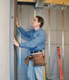 Insulated basement wall panels being placed against a concrete foundation wall in Milford